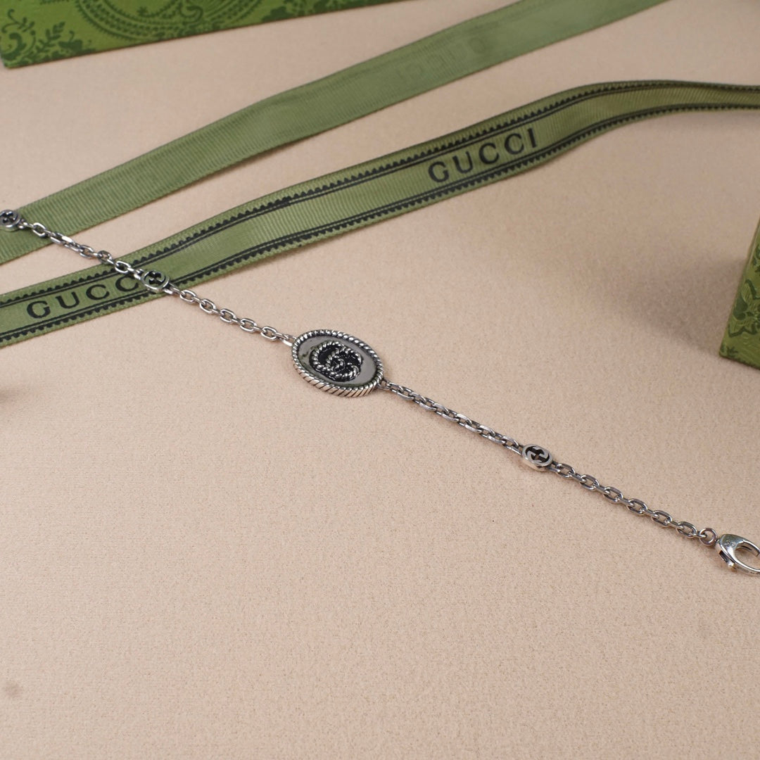 Gucci bracelet with oval logo medallion, silver-tone link chain and clasp