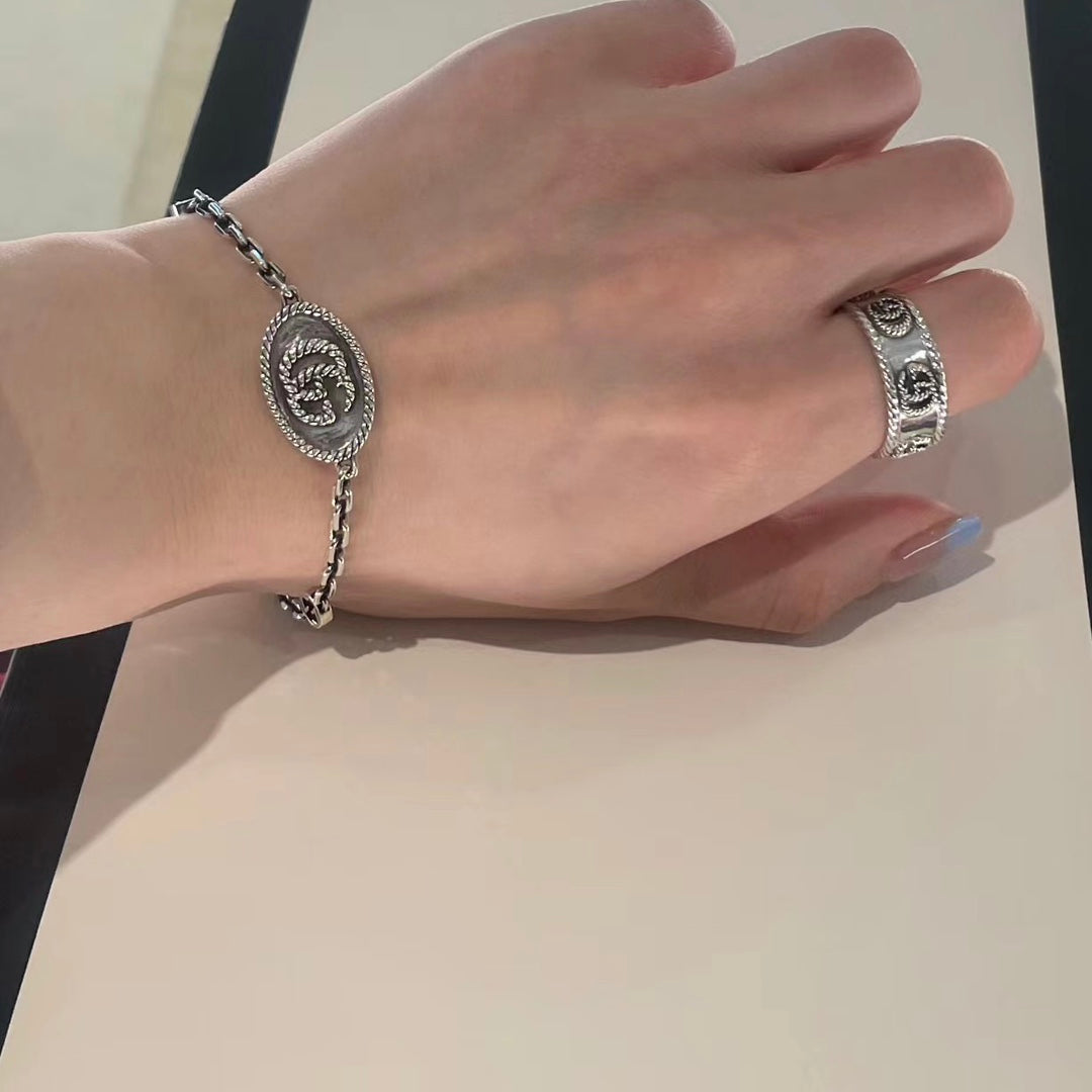Gucci bracelet on wrist, oval logo charm with silver-tone chain