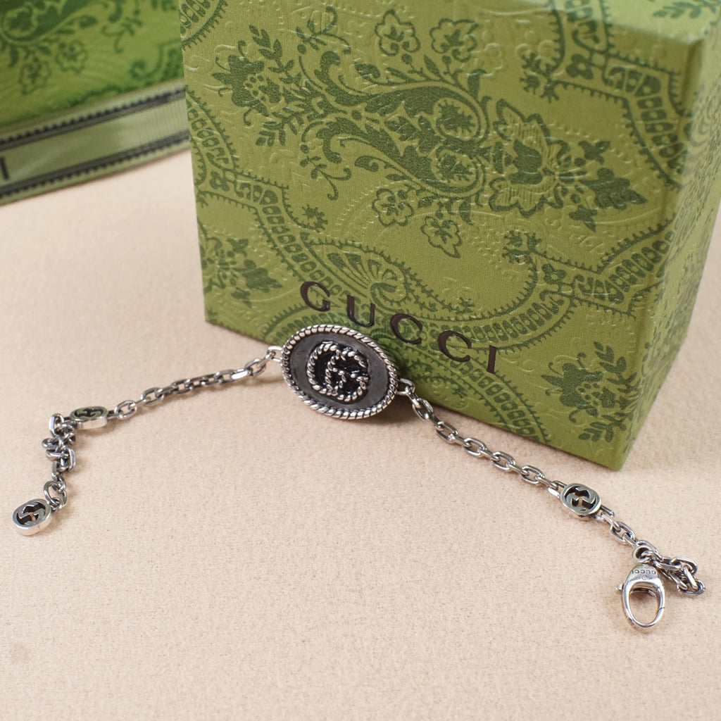 Gucci bracelet with oval logo charm, silver-tone chain and extender ring