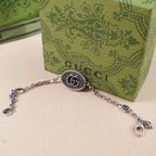 Gucci bracelet with oval logo charm, silver-tone chain and extender ring