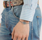 Gucci bracelet on wrist, oval logo charm with silver-tone chain