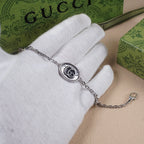 Gucci bracelet with oval logo charm on silver-tone chain