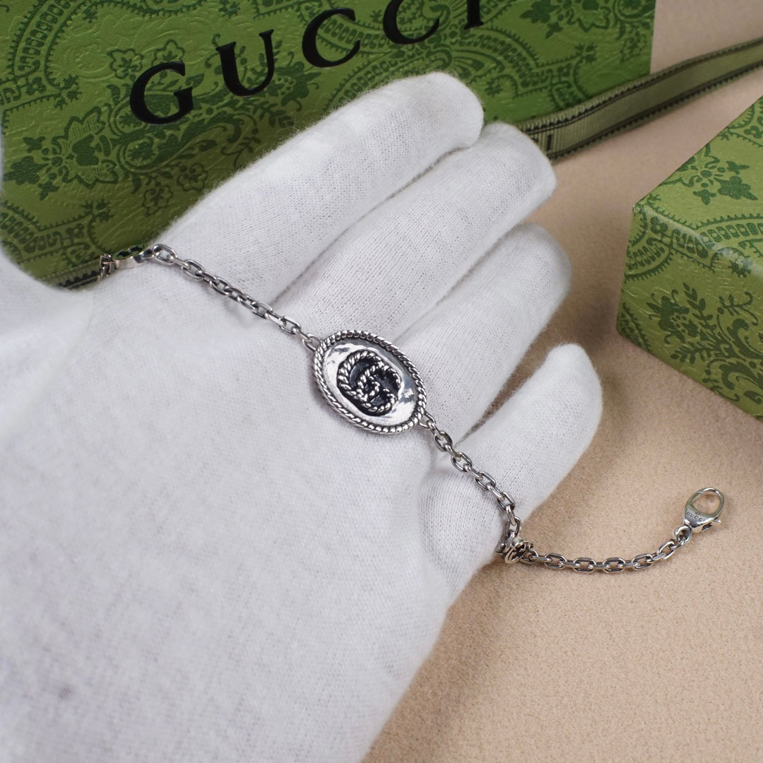 Gucci bracelet with oval logo charm on silver-tone chain