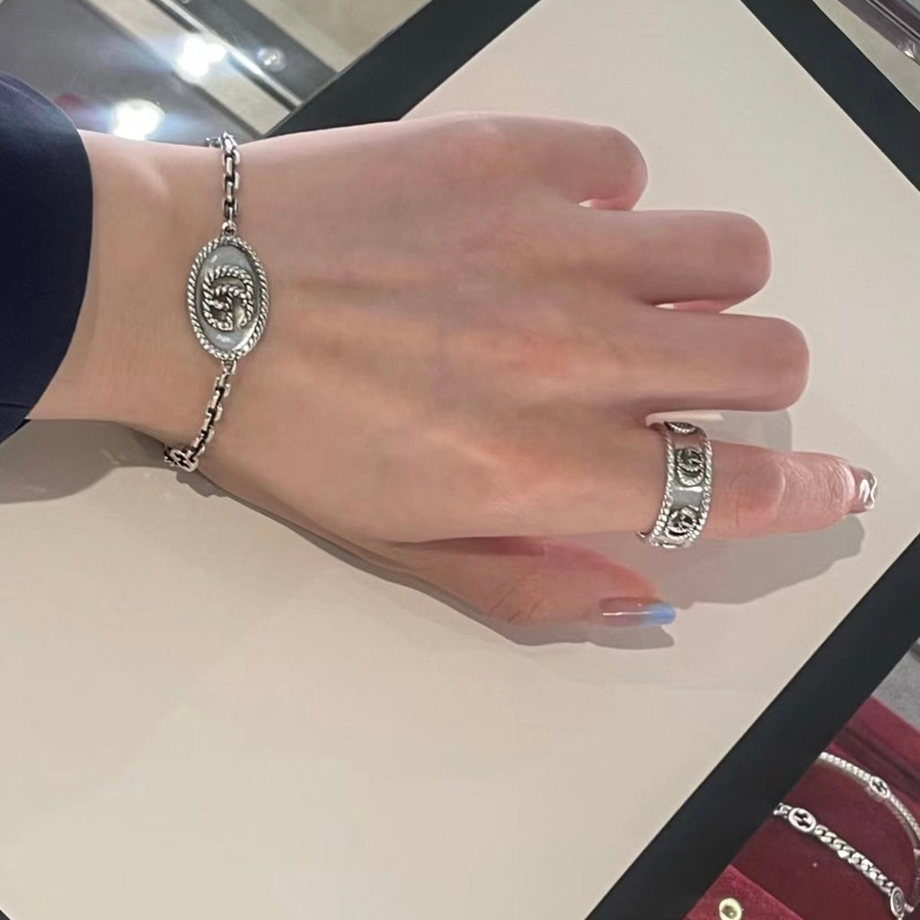 Gucci bracelet on hand, oval logo medallion on silver-tone chain