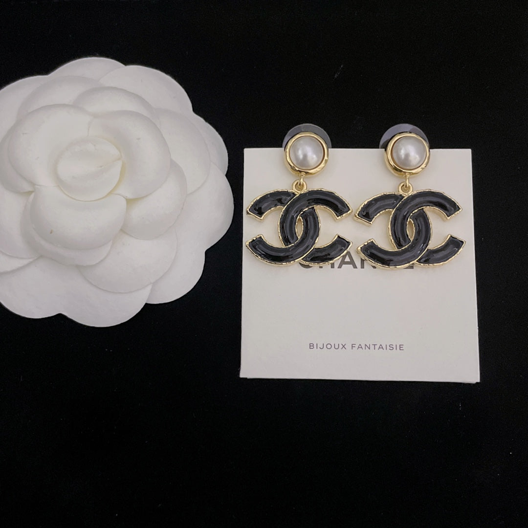 Pair of Chanel-style earrings with black enamel CC drop charms and pearl stud tops