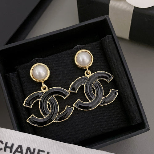 Chanel-style drop earrings with black enamel CC design and round pearl stud tops