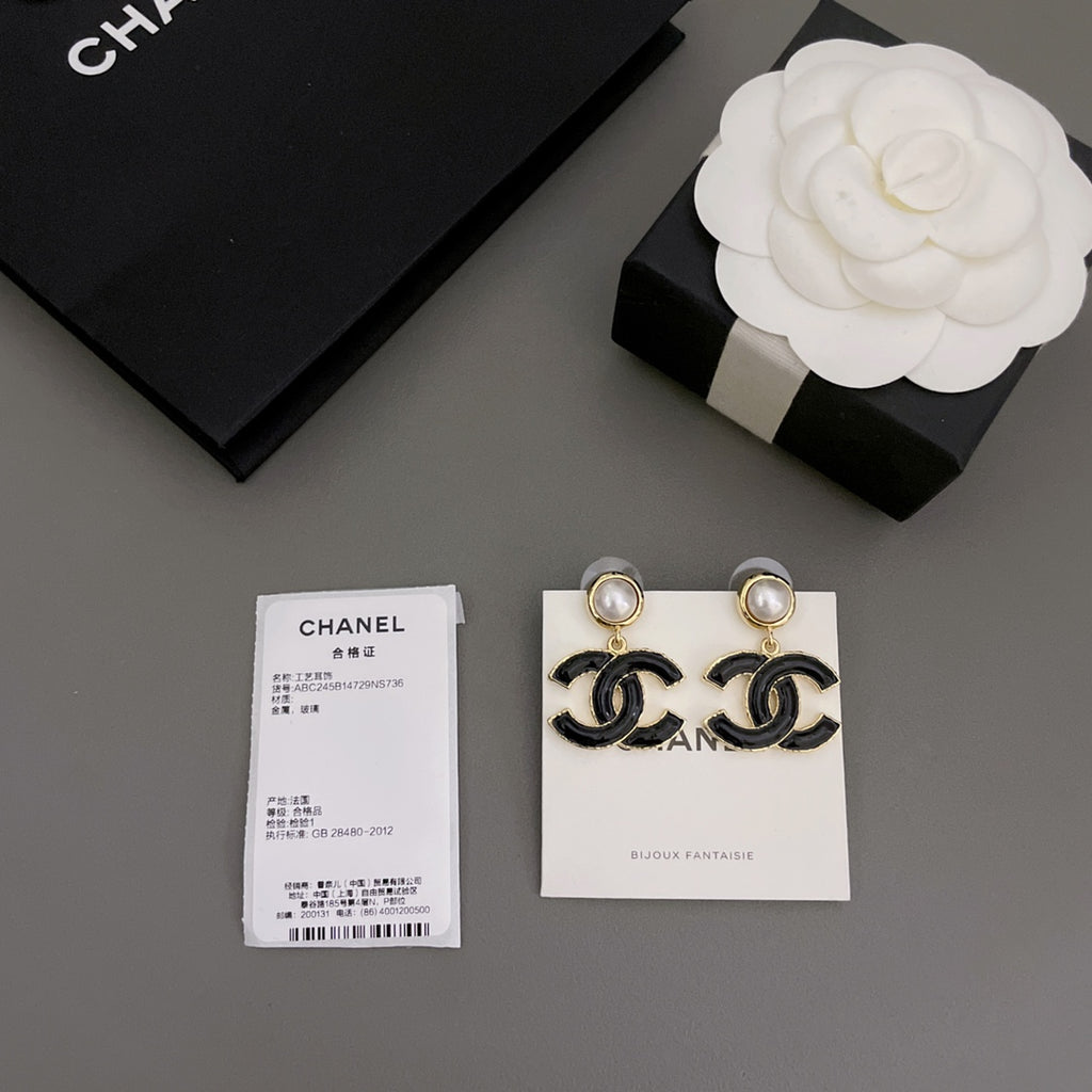 Chanel-style earrings featuring black enamel CC drops with round pearl stud tops