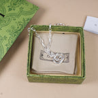 Silver-tone chain necklace with round interlocking GG pendant on beige insert