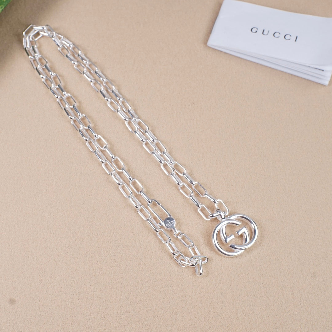 Silver-tone chain necklace with round interlocking GG pendant, extended chain view