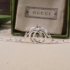Silver-tone interlocking GG pendant with connected chain links and clasp