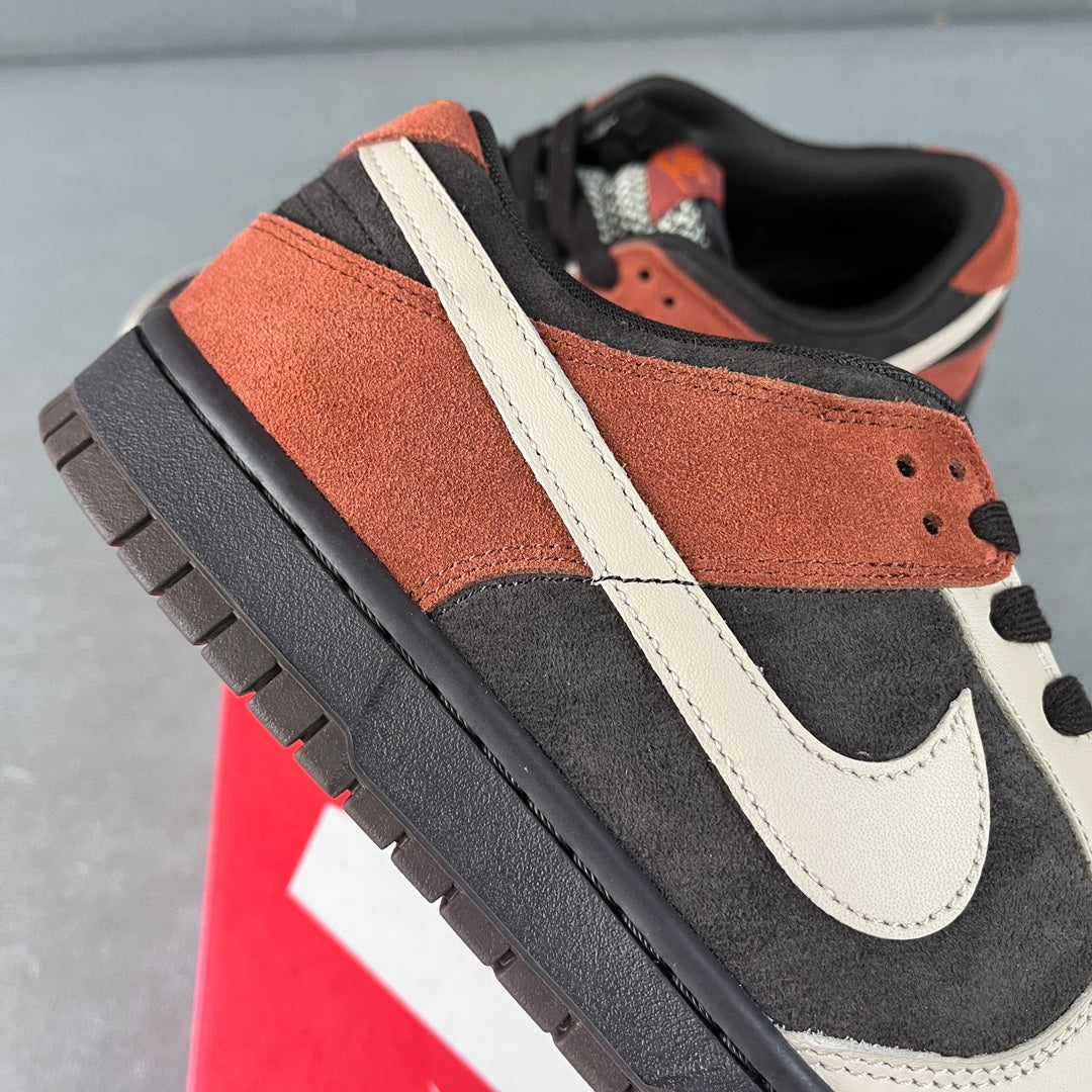 Black and white low-top sneaker with orange-brown suede panel and white strap detail