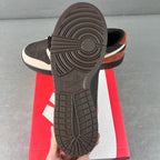 Black rubber outsole with tread pattern on low-top sneaker, white sidewall and orange stripe