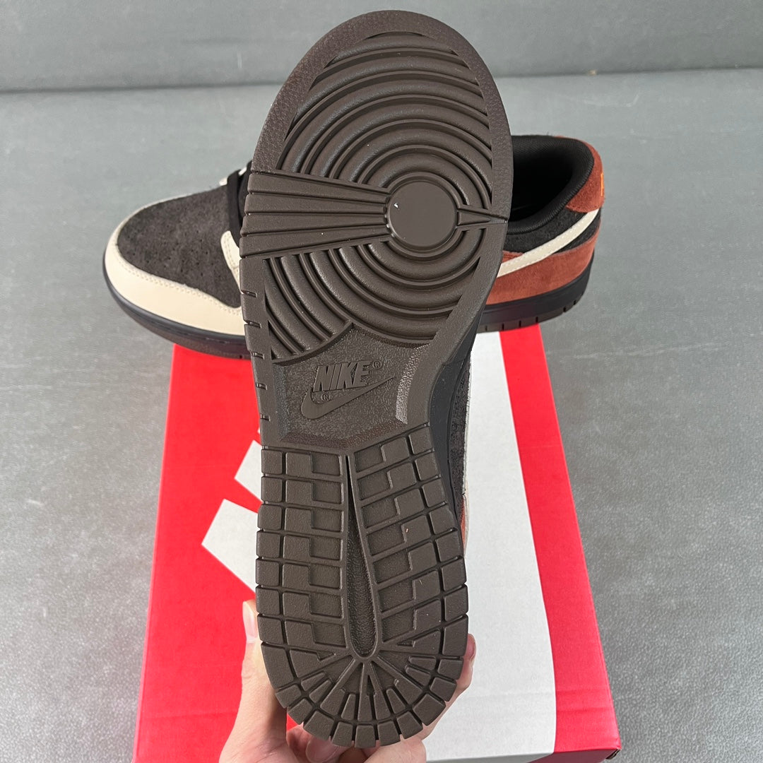 Black rubber outsole with tread pattern on low-top sneaker, white sidewall and orange stripe