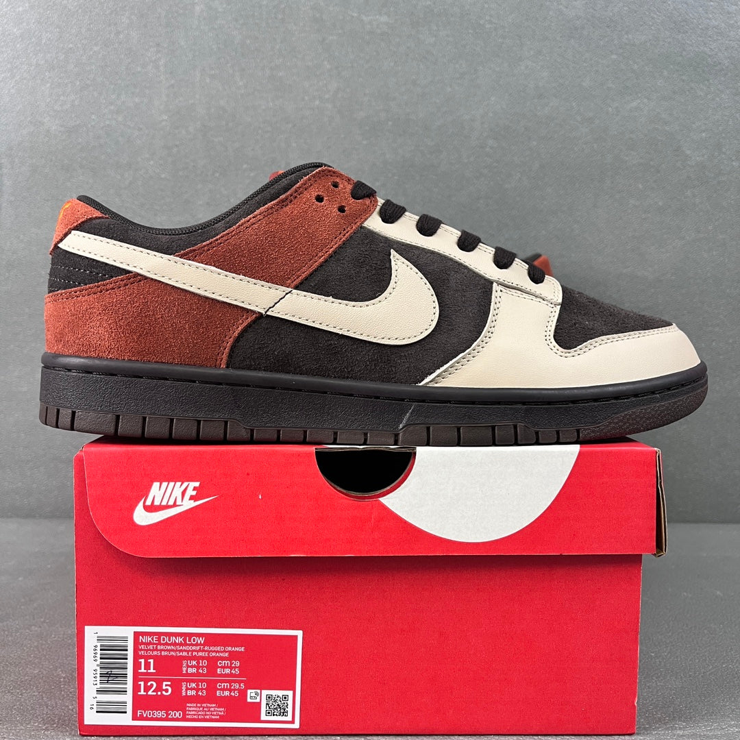 Black, white, and orange low-top sneakers with swoosh and black laces
