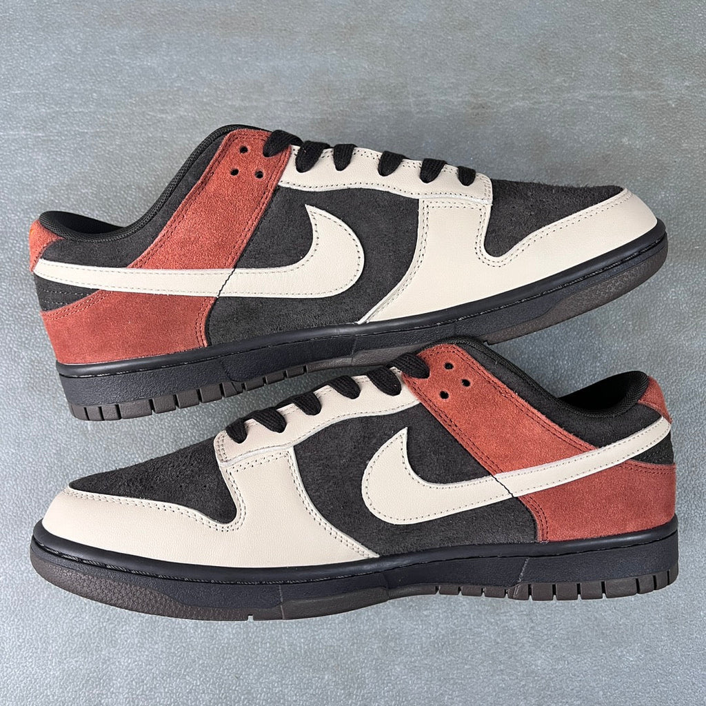 Black, white, and orange-brown low-top sneakers with swoosh, laces, and textured panels