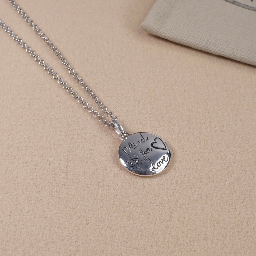Silver heart pendant necklace with engraved script and Gucci logo on chain