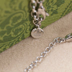Silver Gucci pendant necklace with clasp detail and engraved Gucci text