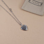 Silver heart pendant necklace with face engraving and Gucci logo on chain