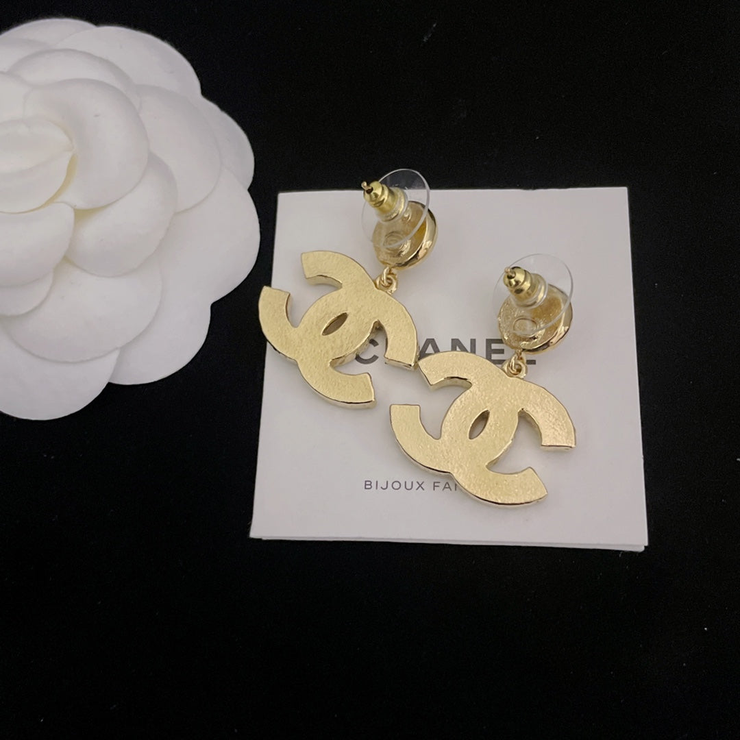 Pair of Chanel-style hoop earrings with gold-tone dangling logo charms and pearl accents