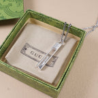 Gucci necklace pendant and chain displayed in a green patterned gift box