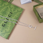 Silver-tone necklace with ring charm and horizontal bar pendant