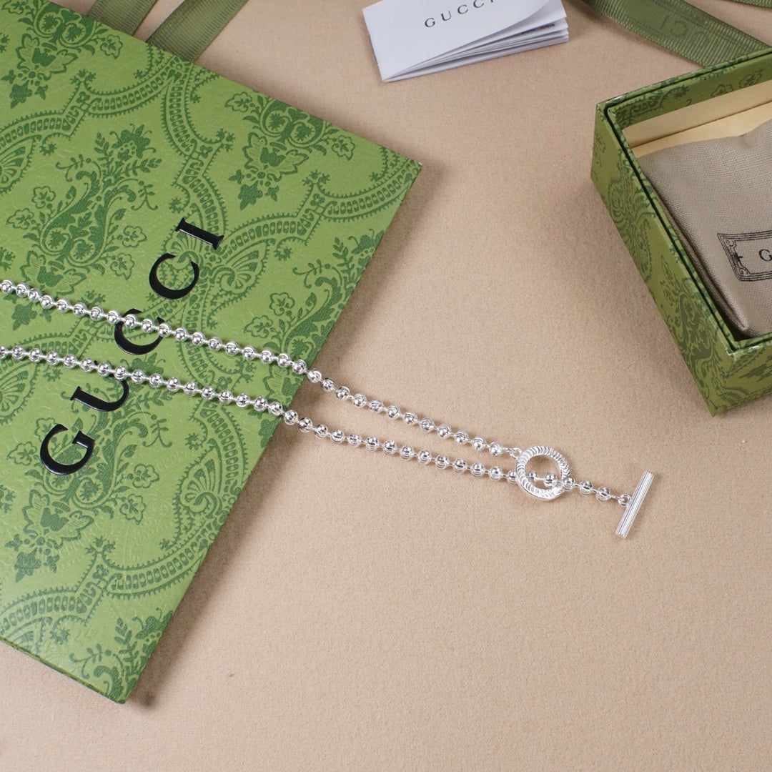 Silver-tone necklace with ring charm and horizontal bar pendant