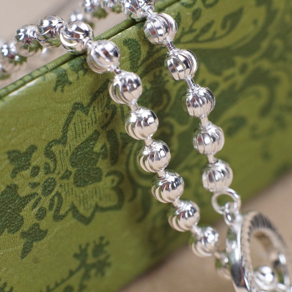 Silver-tone bead bracelet with circular ring pendant and bar charm