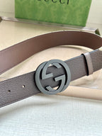 Gucci belt close-up: dark brown leather strap with round silver GG logo buckle