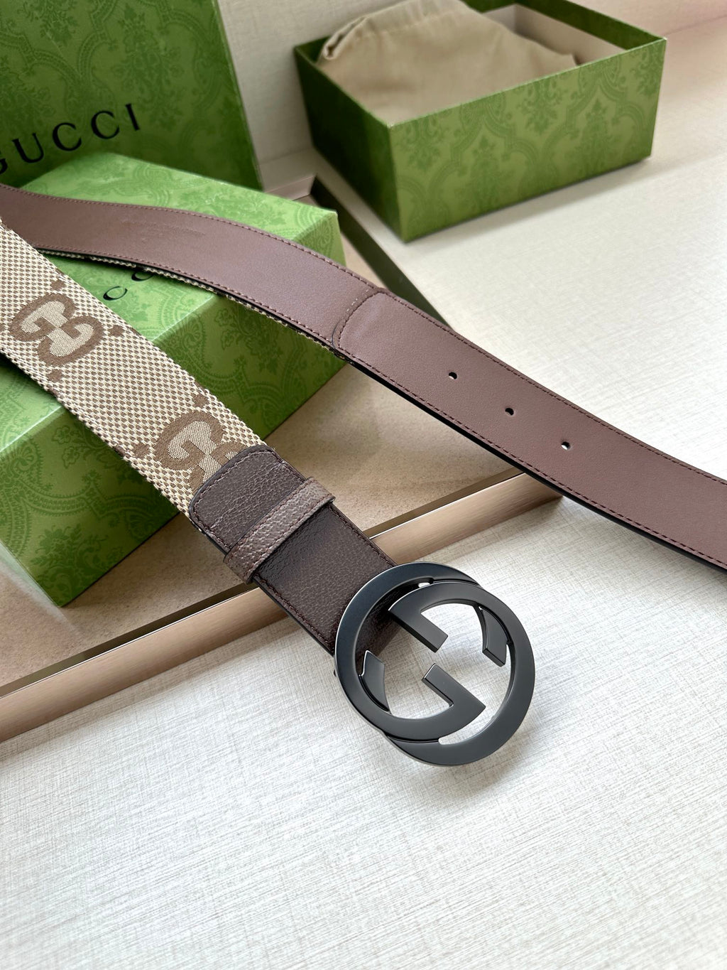 Gucci belt with dark brown leather strap and round silver GG logo buckle
