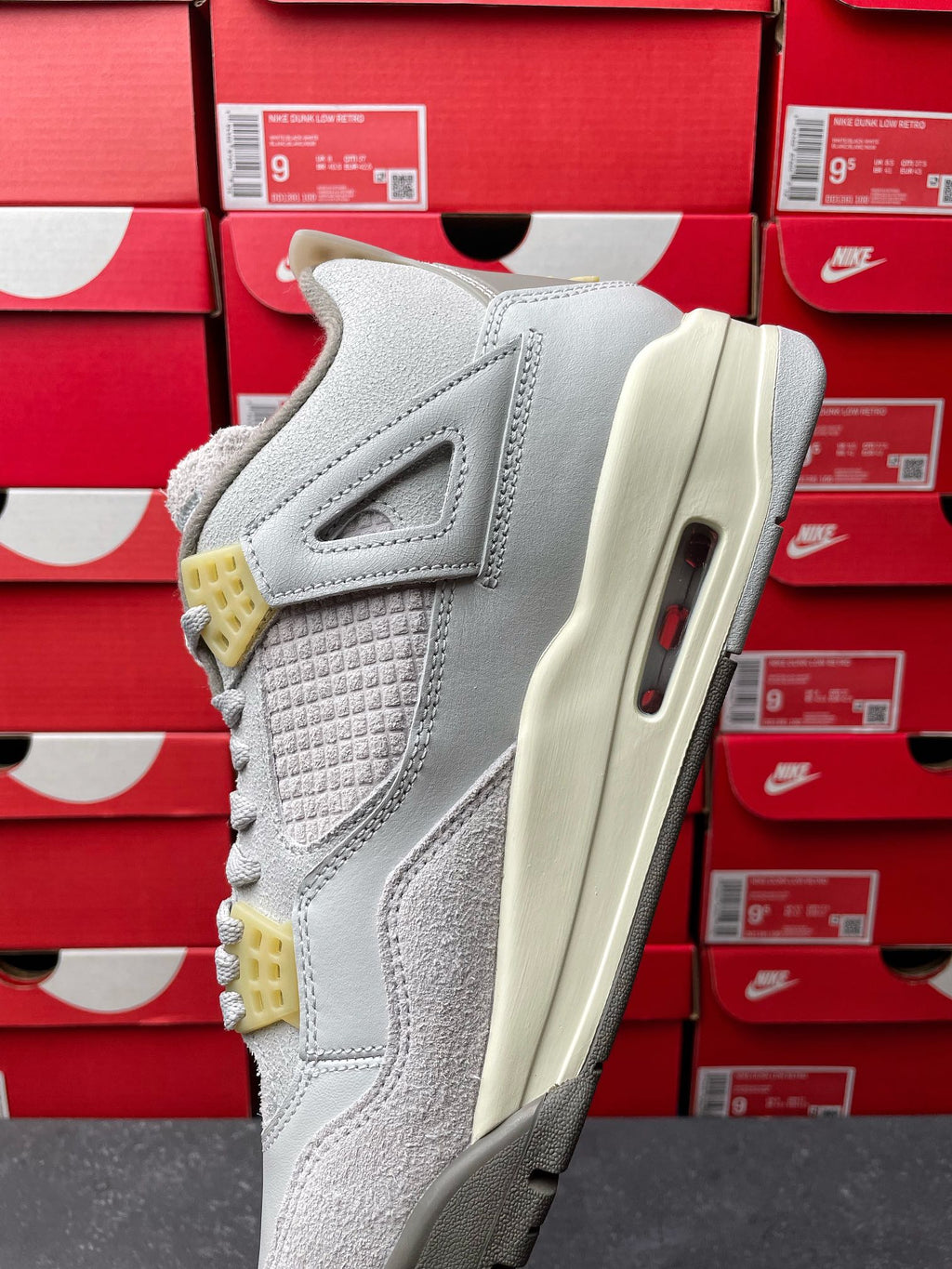 Light gray Air Jordan 4 sneaker side view with quilted upper, cream midsole and visible Air unit
