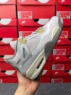 Light gray Air Jordan 4 sneaker side view with quilted upper, cream midsole and Air unit