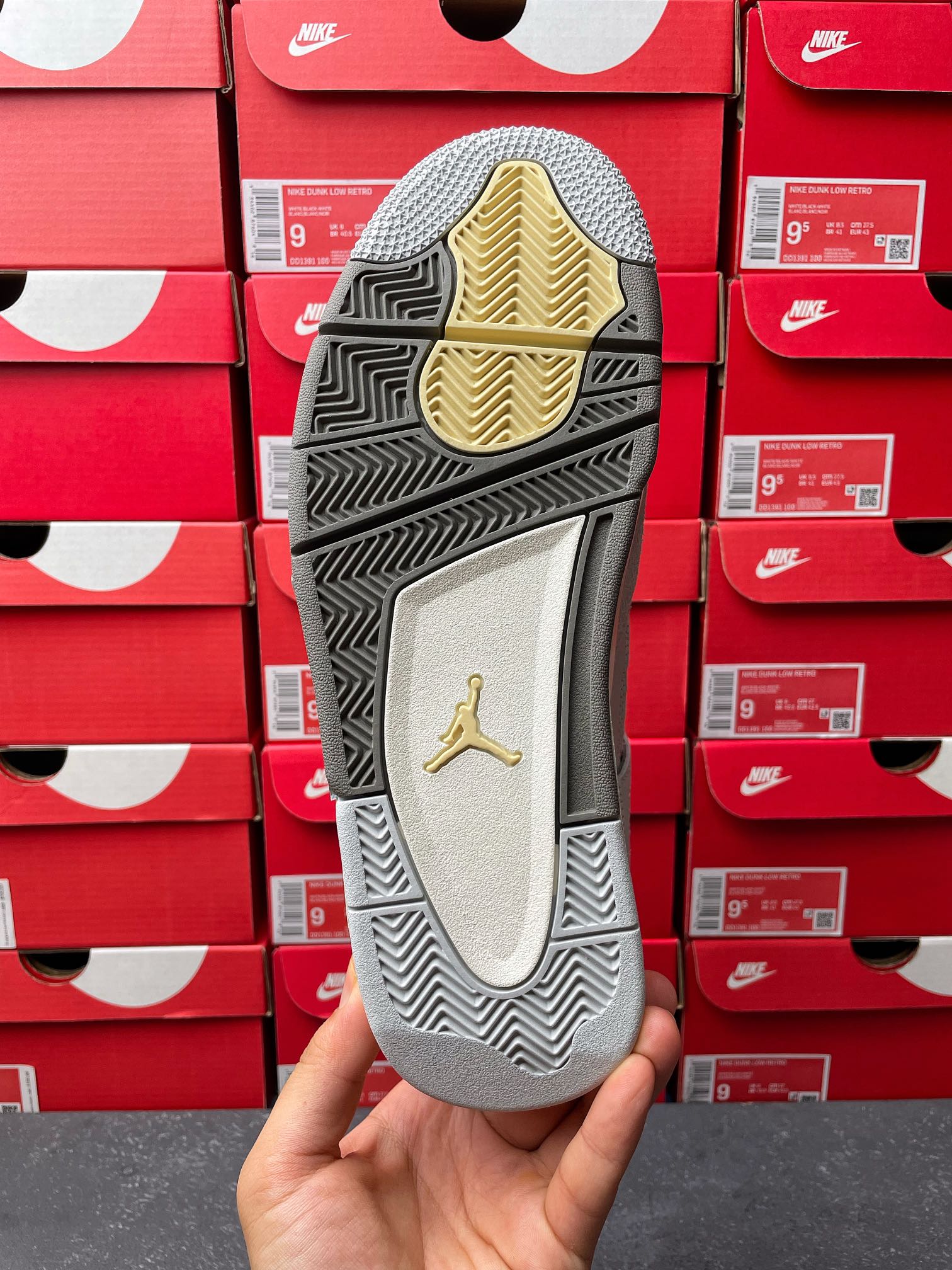 Light gray Air Jordan 4 sneaker outsole view with Jordan logo and patterned traction