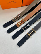 Assorted leather belts with metal buckles in taupe, tan, and dark blue
