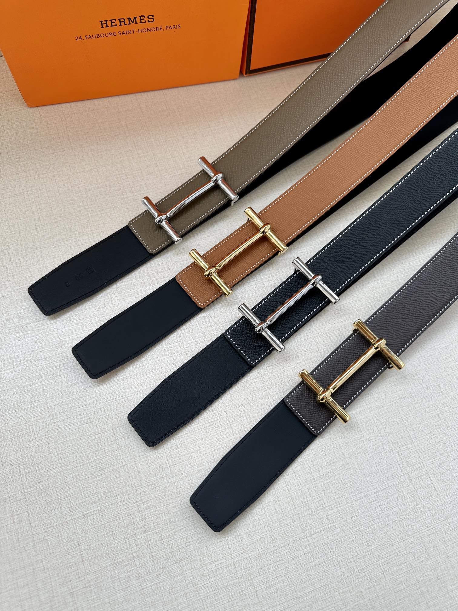 Assorted leather belts with metal buckles in taupe, tan, and dark blue