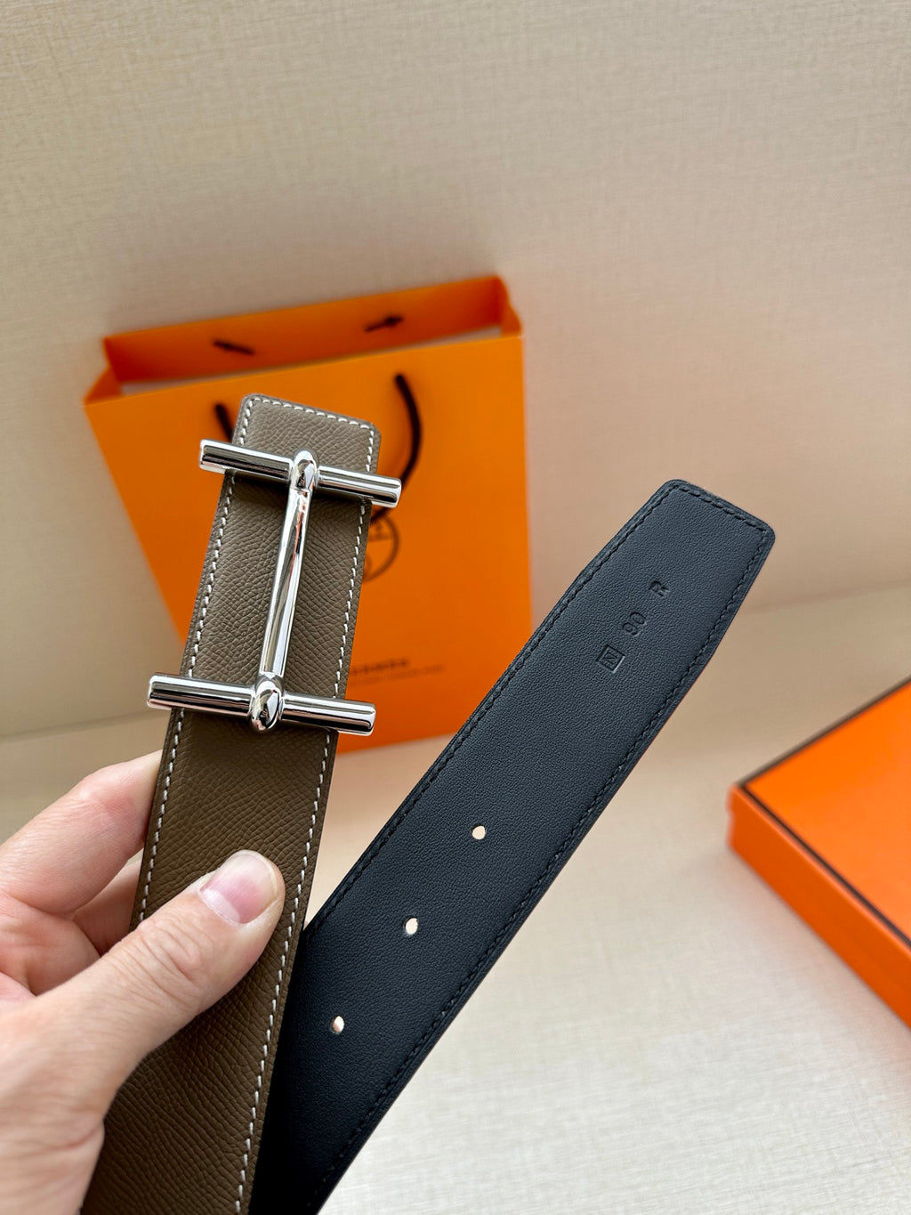 Leather belt with textured strap, silver double-prong buckle, punched holes