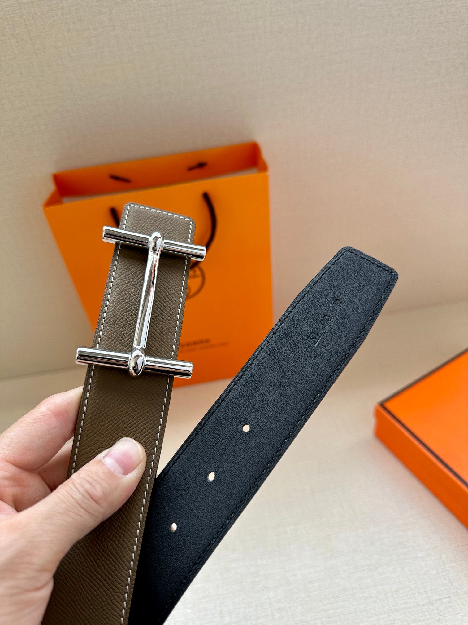 Leather belt with textured strap, silver double-prong buckle, punched holes