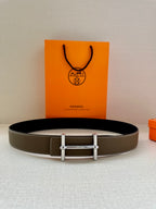 Taupe leather belt with silver double-prong buckle laid flat