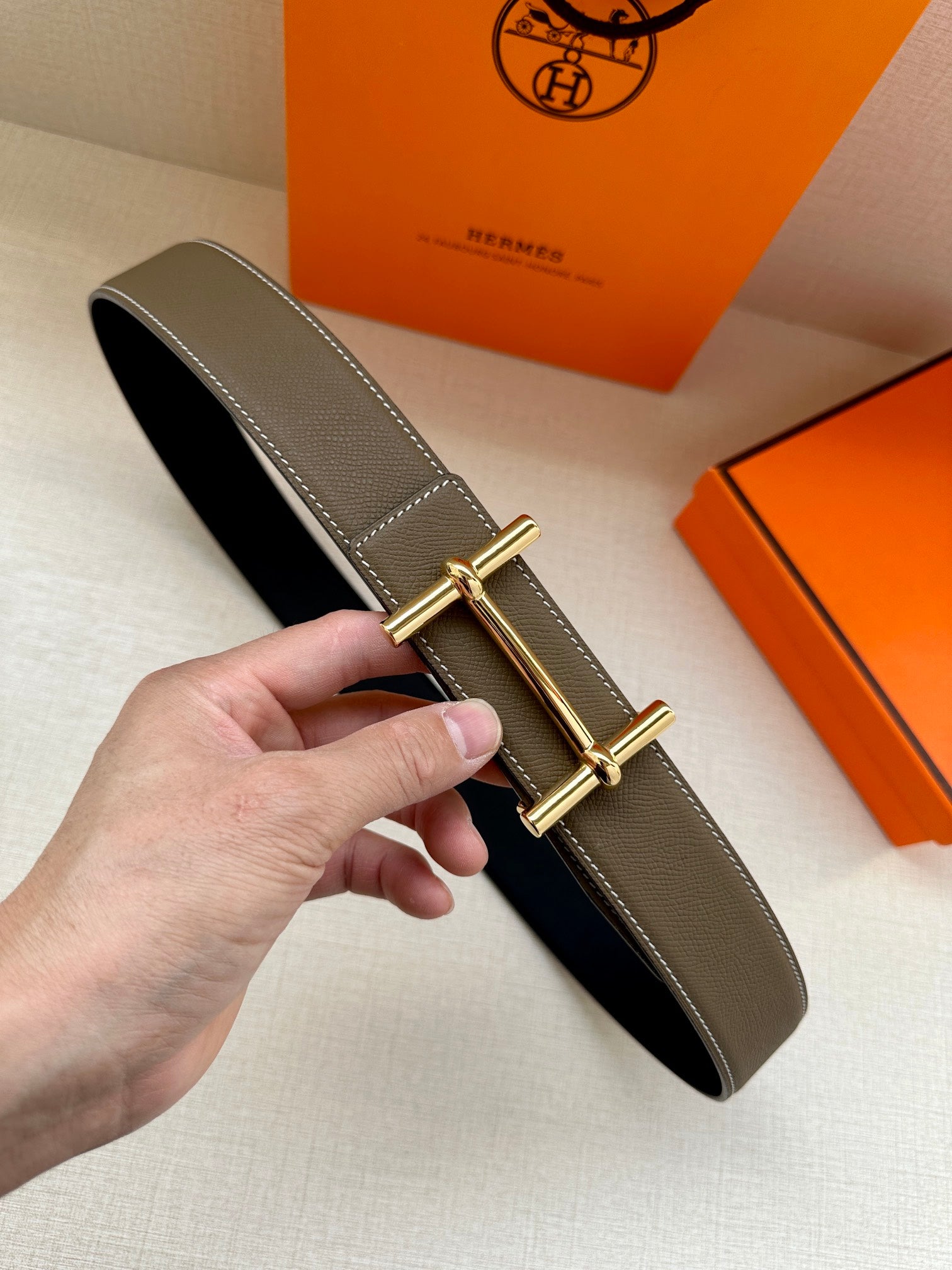 Leather belt with dark taupe finish and gold double-prong buckle
