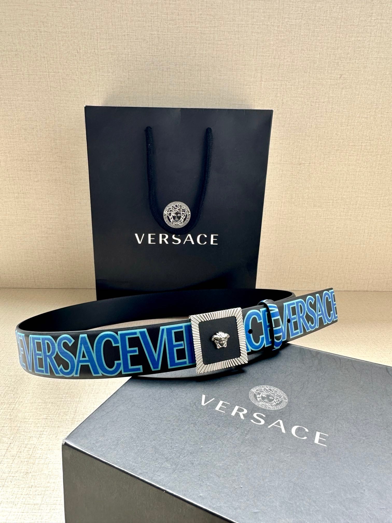 Versace logo belt with blue webbing and gold buckle clasp, Medusa emblem.