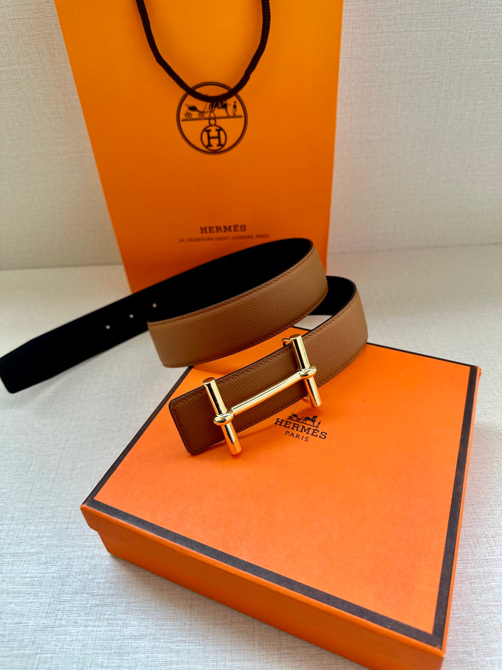 Hermes leather belt in tan with silver buckle, paired with dark strap interior