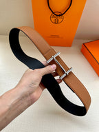 Hermes leather belt in tan with silver buckle, underside shown as dark interior