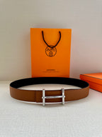 Hermes leather belt in tan with silver double-prong buckle, laid flat view