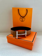 Hermes leather belt in tan with silver buckle, front view on display setup
