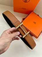 Hermes leather belt in tan with silver double-prong buckle and crossbar design