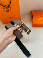 Gray leather belt with gold-toned double-bar buckle and punched adjustment holes