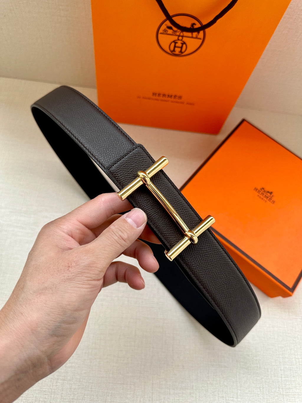 Hermes belt with dark textured leather strap and gold-tone double-bar buckle