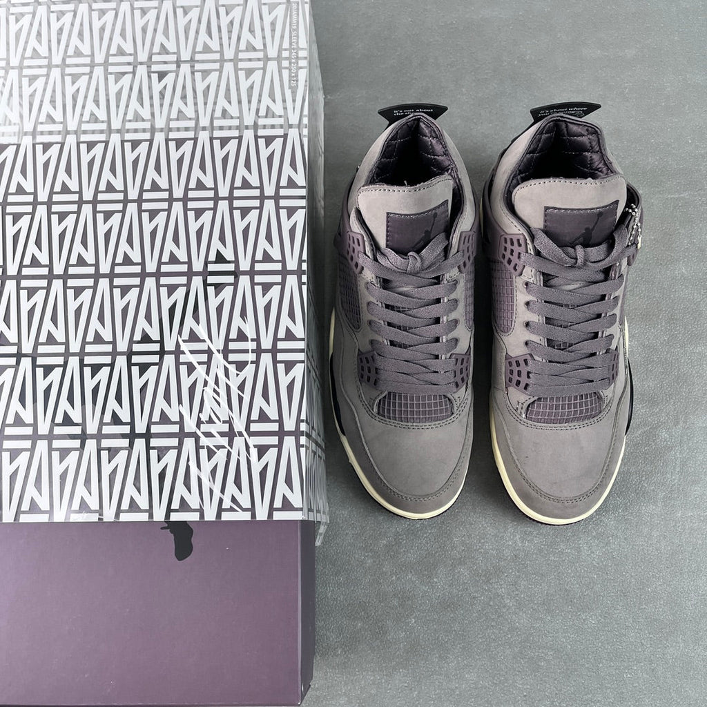 Grey Air Jordan 4 sneakers in pair, angled side view with lace-up uppers