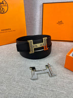 Dark leather belt with gold-tone rectangular buckle on display stand