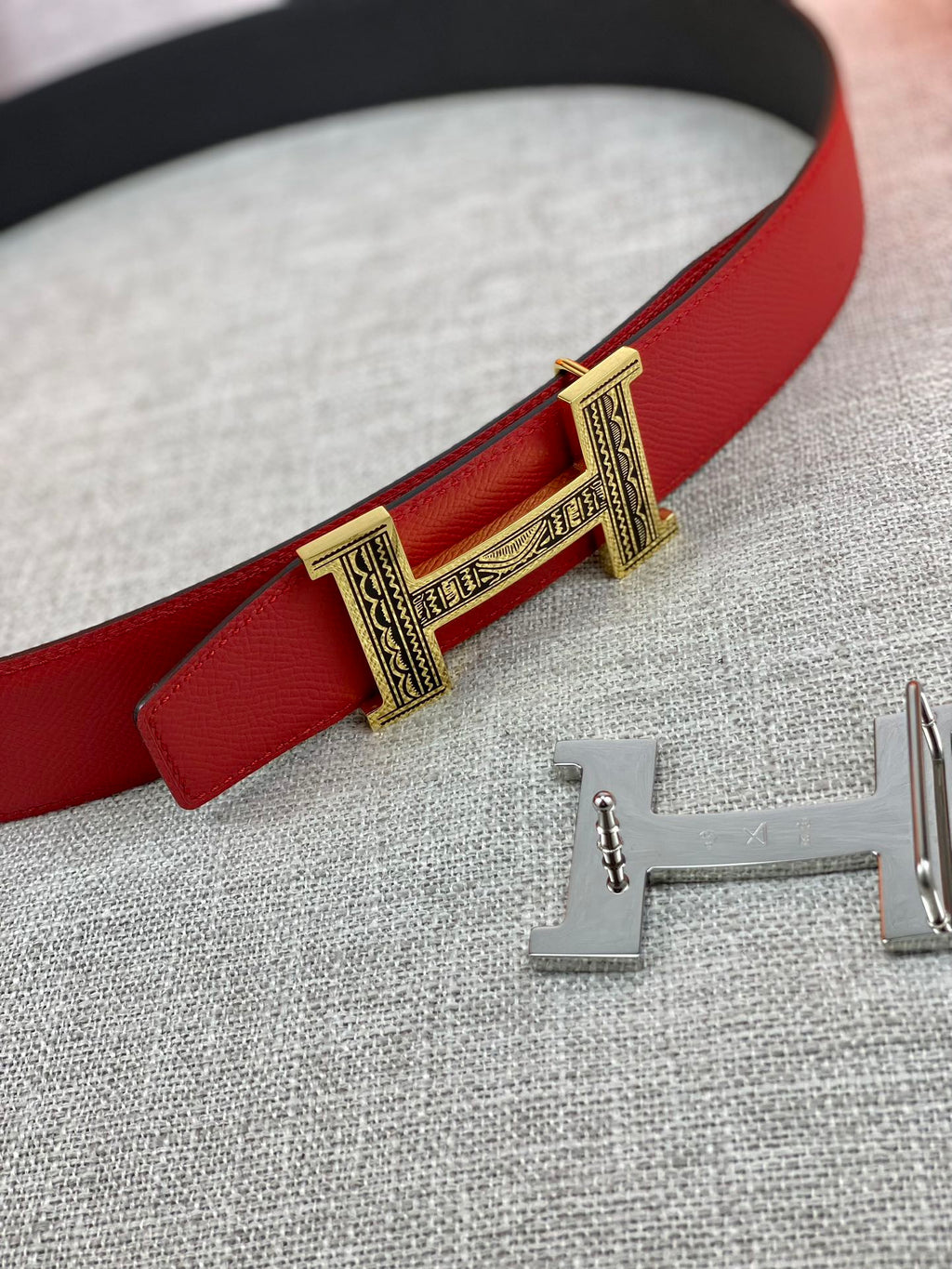 Red belt strap with silver buckle clasp and engraved center detail