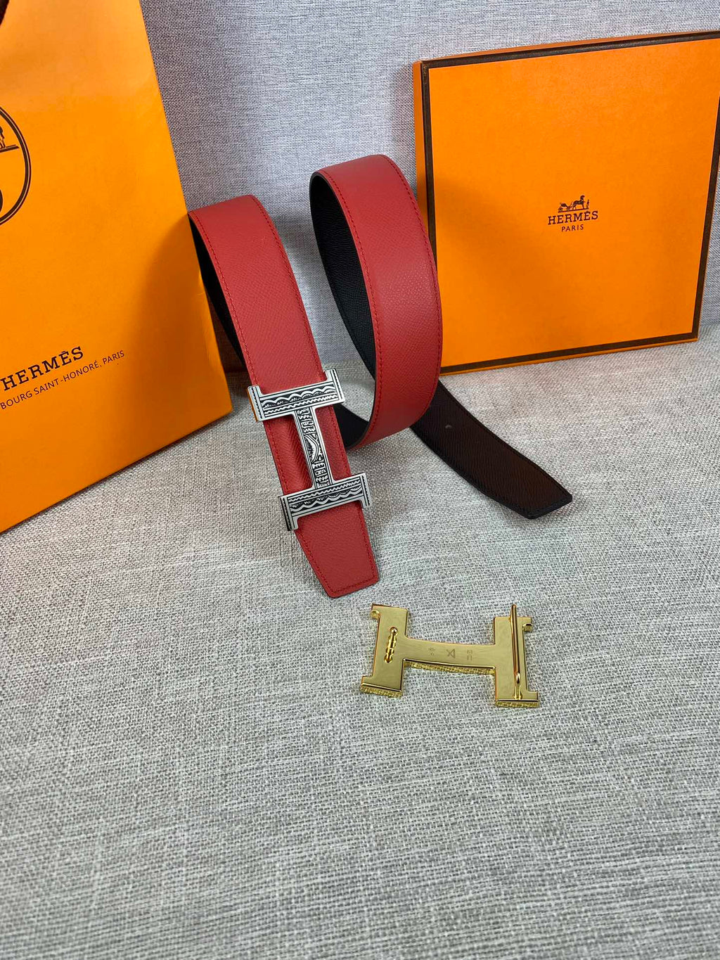 Red and black belt with silver H buckle and gold H buckle piece